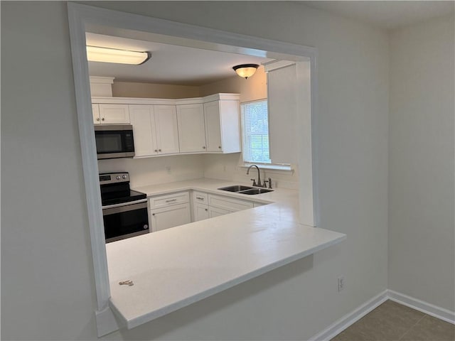 208 Stafford Ave, Brunswick, GA 31520 - kitchen with appliances with stainless steel finishes, white cabinets, light countertops, and a peninsula