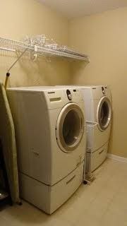 clothes washing area featuring laundry area, washing machine and dryer, and baseboards