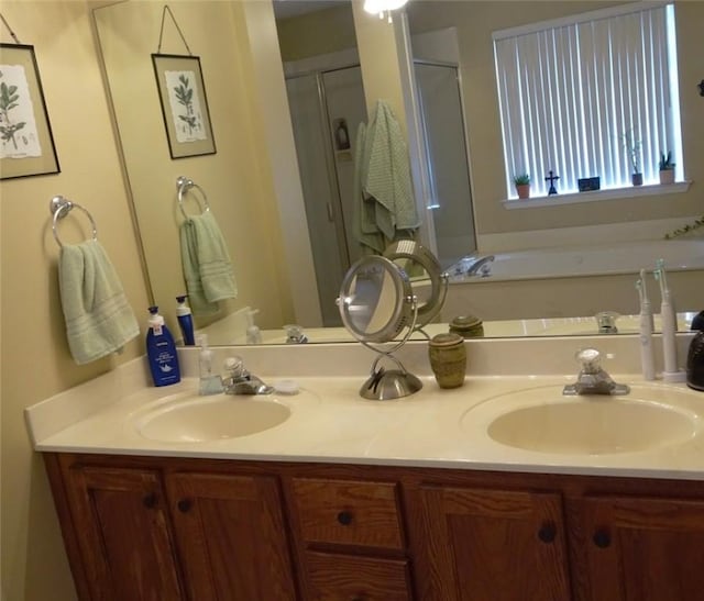 full bath with a sink, a garden tub, a stall shower, and double vanity