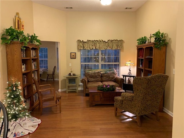 living area featuring visible vents, baseboards, and wood finished floors