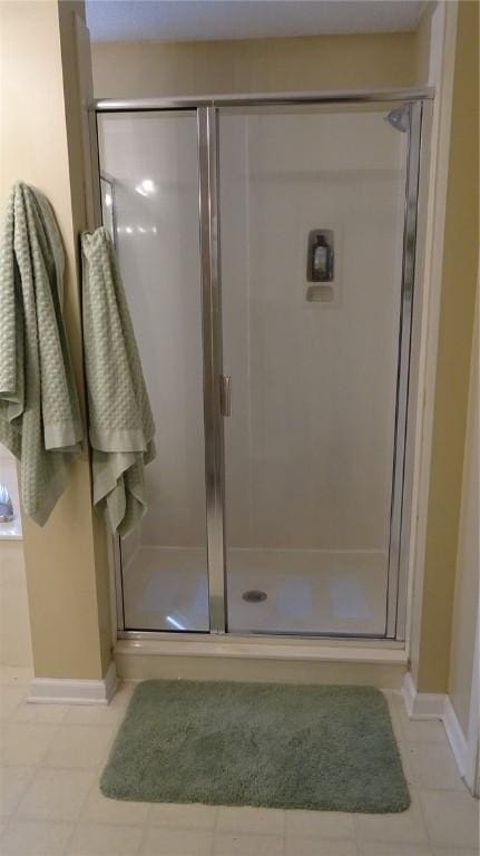 full bath featuring baseboards and a stall shower