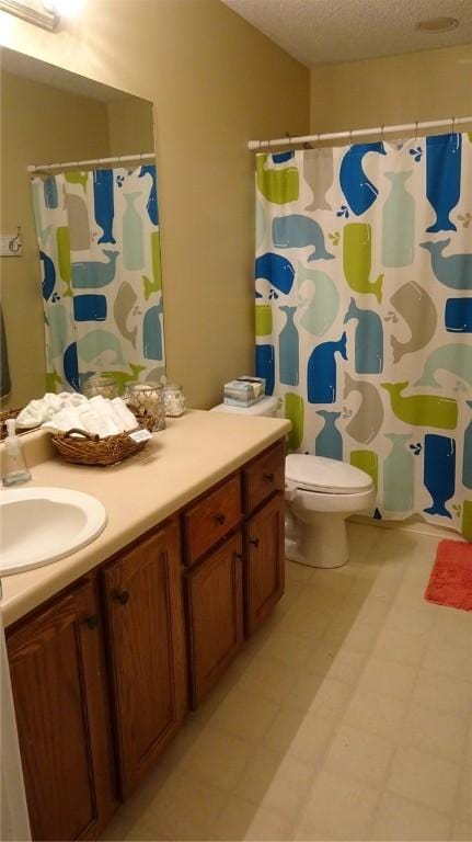 full bathroom with toilet, vanity, a shower with shower curtain, tile patterned floors, and a textured ceiling