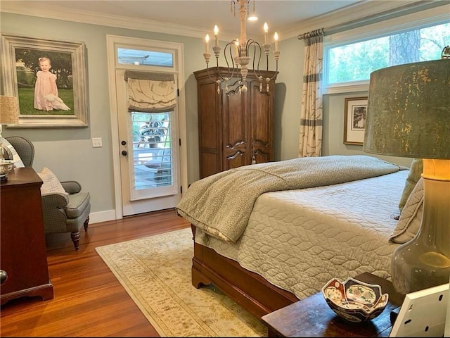 bedroom with a notable chandelier, wood-type flooring, and ornamental molding