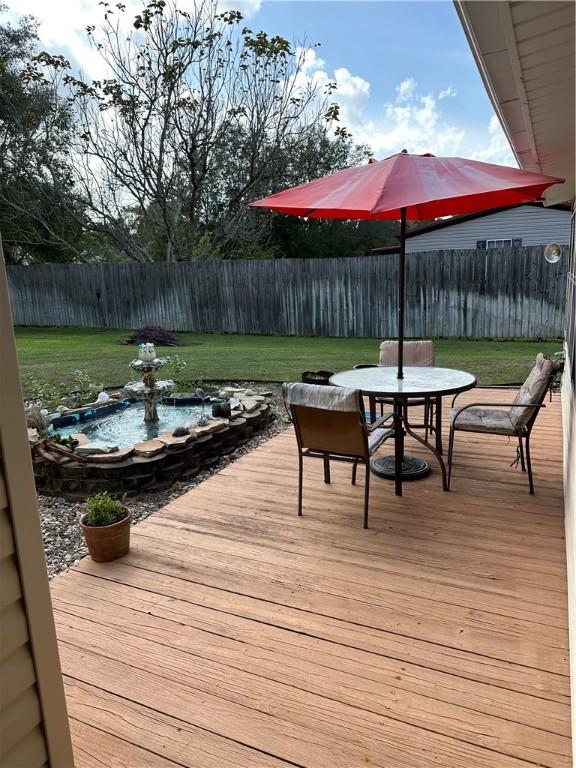 wooden terrace featuring a lawn