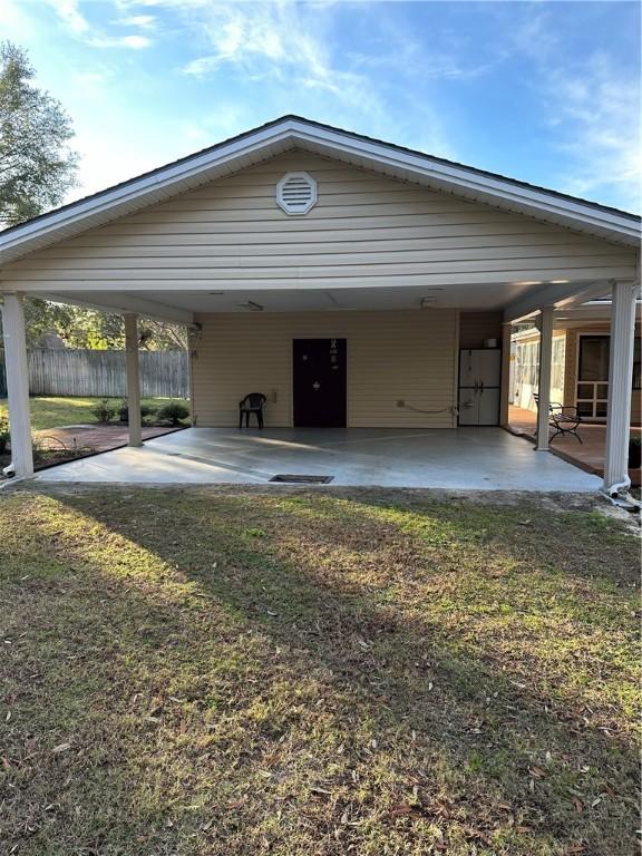 view of vehicle parking featuring a carport and a yard