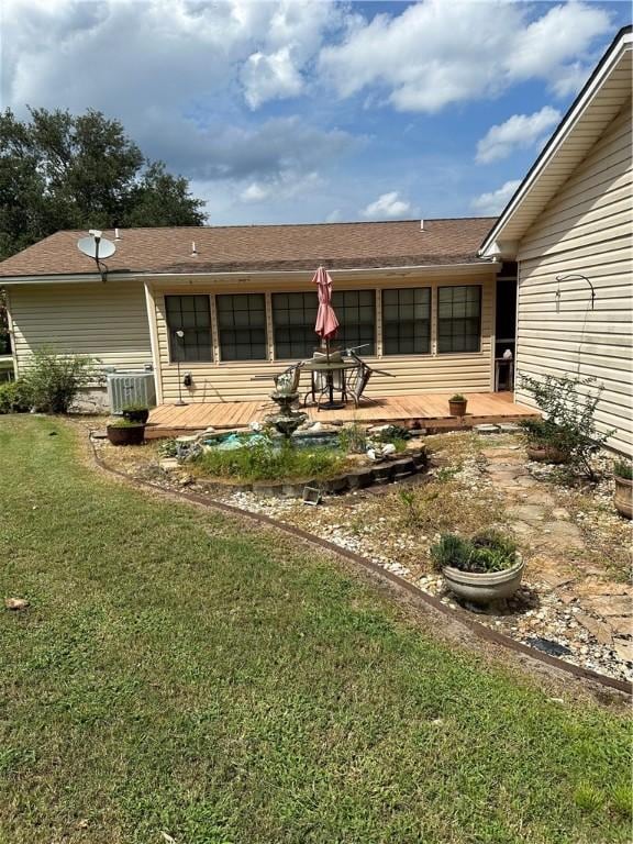 back of house featuring central AC and a lawn