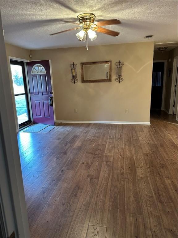 interior space with wood-type flooring, a textured ceiling, and ceiling fan