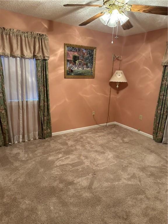 spare room with carpet flooring, a textured ceiling, and ceiling fan