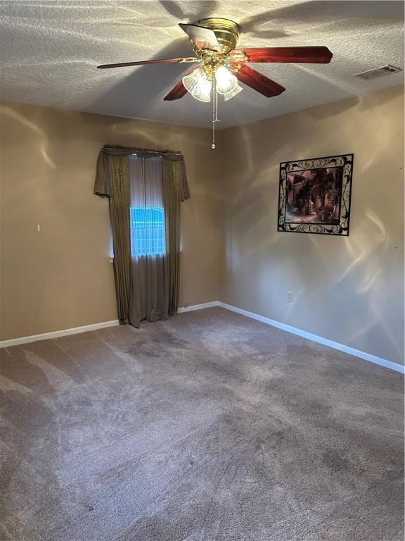 empty room featuring carpet, ceiling fan, and a textured ceiling