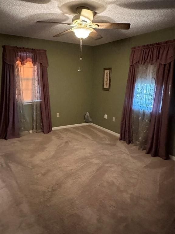 unfurnished room with carpet flooring, plenty of natural light, and a textured ceiling