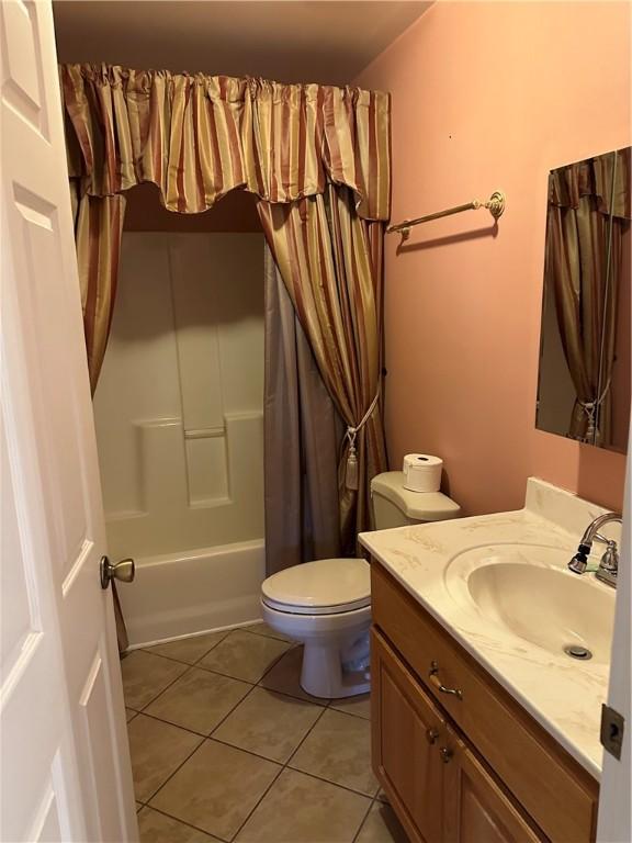 full bathroom with tile patterned flooring, shower / bath combination with curtain, toilet, and vanity