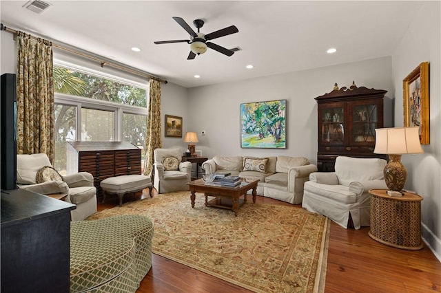 living room featuring dark hardwood / wood-style flooring and ceiling fan