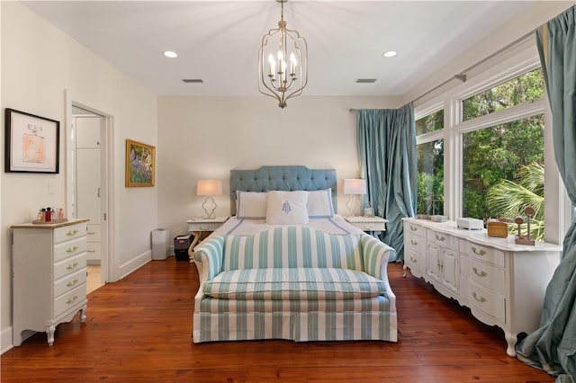 bedroom featuring dark wood-type flooring and an inviting chandelier