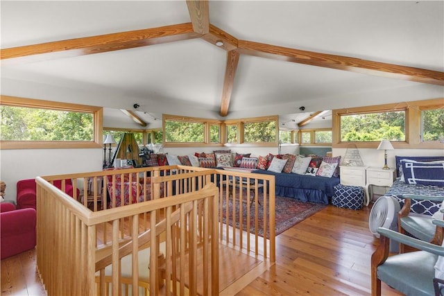 living room with hardwood / wood-style floors, lofted ceiling with beams, and a healthy amount of sunlight