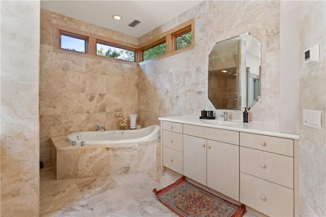 bathroom featuring vanity, tile walls, and tiled tub