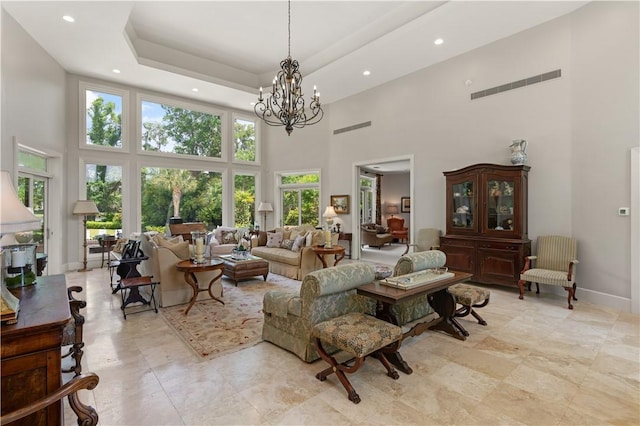 living room with a wealth of natural light, a high ceiling, and an inviting chandelier