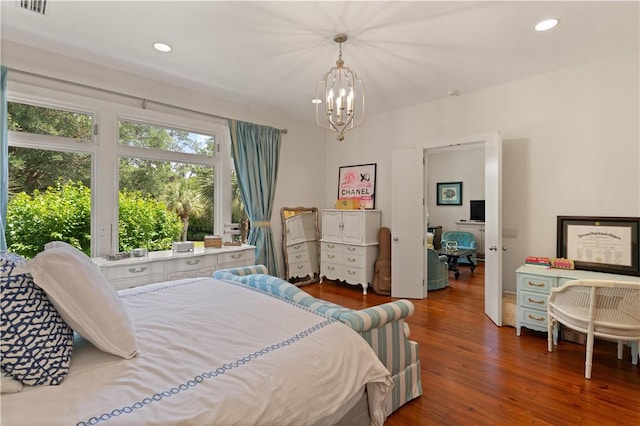 bedroom featuring dark hardwood / wood-style floors and an inviting chandelier