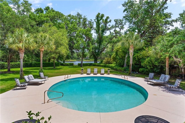 view of pool featuring a patio area, a yard, and a water view