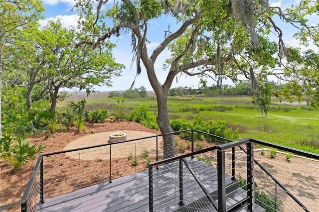 wooden deck with a fire pit and a rural view