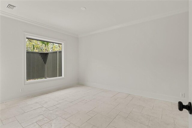 spare room featuring baseboards, ornamental molding, and visible vents