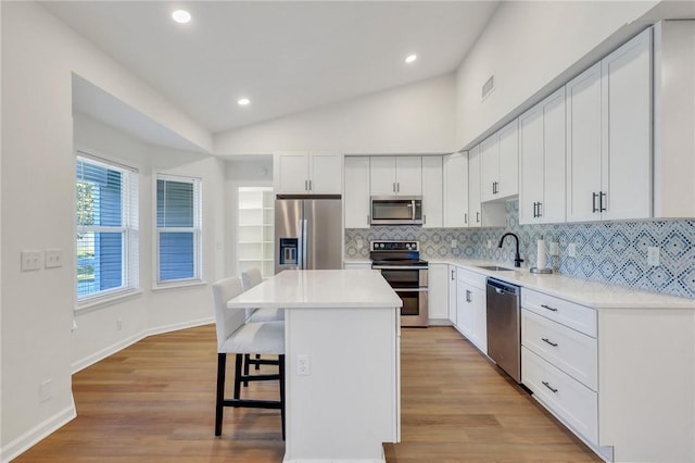 kitchen with white cabinets, a kitchen island, sink, and stainless steel appliances