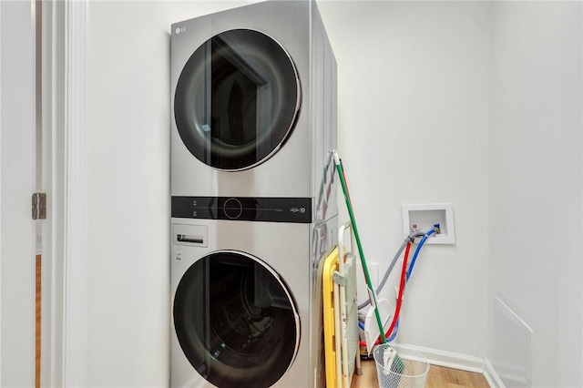 washroom featuring hardwood / wood-style floors and stacked washer / drying machine