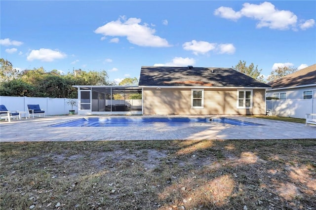 rear view of property with a fenced in pool, a patio area, and a sunroom