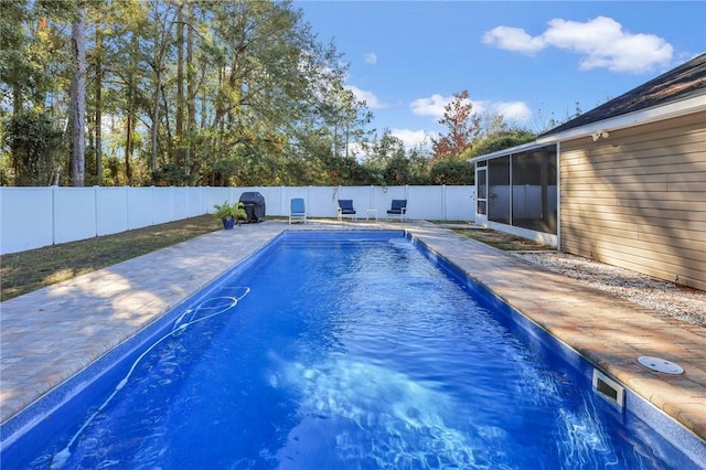 view of swimming pool featuring a sunroom