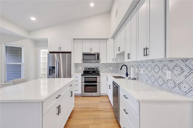 kitchen featuring white cabinetry, a center island, lofted ceiling, and appliances with stainless steel finishes