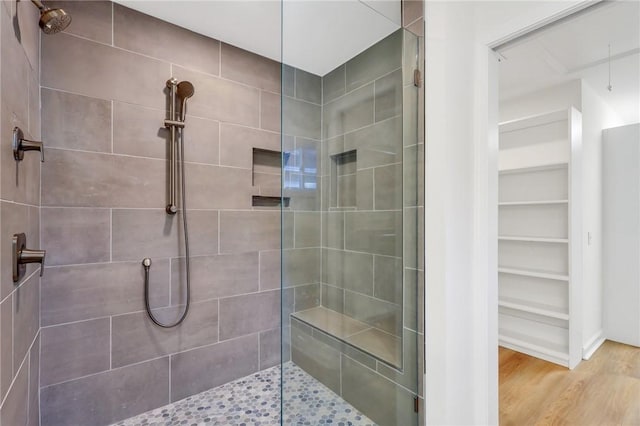 bathroom featuring a tile shower and hardwood / wood-style floors