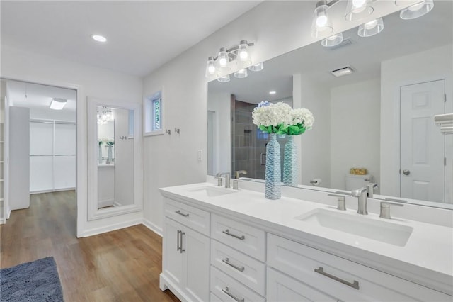 bathroom featuring vanity, toilet, wood-type flooring, and walk in shower