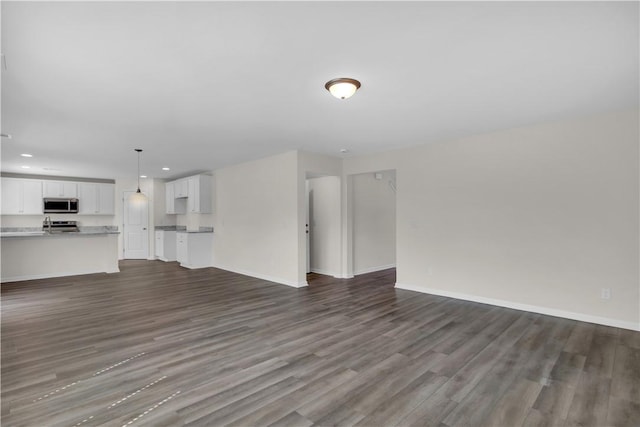 unfurnished living room with dark wood-type flooring