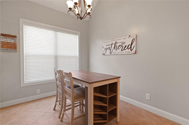 dining area with baseboards, a chandelier, light tile patterned flooring, and vaulted ceiling