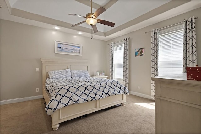 bedroom featuring a ceiling fan, carpet floors, baseboards, a tray ceiling, and recessed lighting