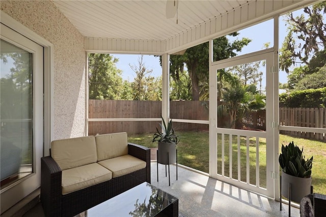 sunroom / solarium featuring ceiling fan and an outdoor hangout area