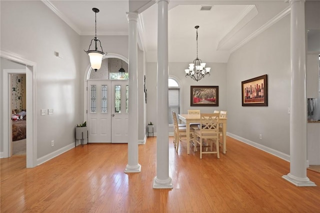 entryway featuring visible vents, crown molding, light wood-style floors, baseboards, and ornate columns