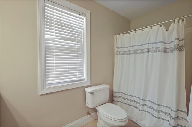 bathroom with baseboards, a shower with curtain, and toilet