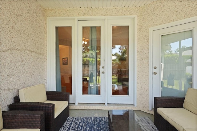 view of exterior entry with an outdoor living space, stucco siding, and french doors