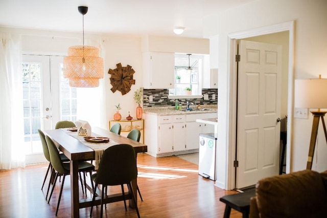 dining space with light hardwood / wood-style floors, sink, and french doors