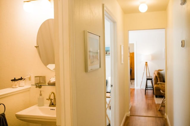 hallway featuring hardwood / wood-style floors and sink