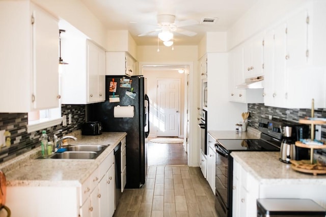 kitchen with white cabinets, black appliances, custom range hood, and wood-type flooring