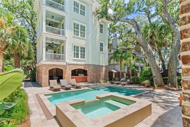 622 Beachview Dr, Saint Simons Island, GA 31522 - back of property featuring a balcony, brick siding, a ceiling fan, an in-ground hot tub, and a patio