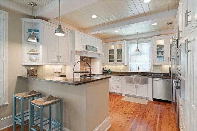 622 Beachview Dr, Saint Simons Island, GA 31522 - kitchen with a peninsula, appliances with stainless steel finishes, light wood-type flooring, white cabinetry, and a wooden ceiling with exposed beams