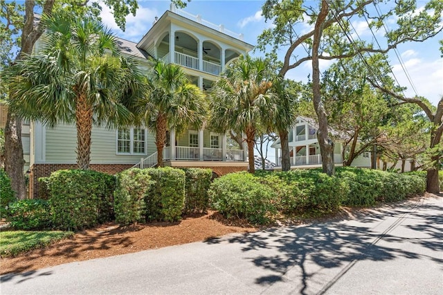 622 Beachview Dr, Saint Simons Island, GA 31522 - view of front facade featuring a balcony, brick siding, stairway, and a porch