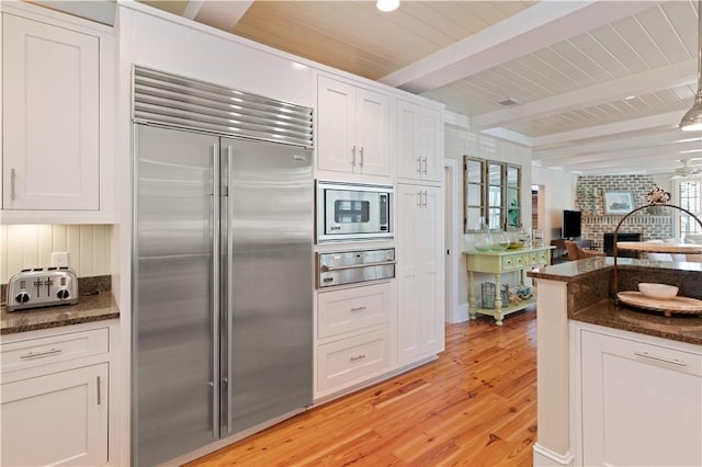 622 Beachview Dr, Saint Simons Island, GA 31522 - kitchen with built in appliances, a warming drawer, light wood-style floors, white cabinetry, and a wooden ceiling with exposed beams