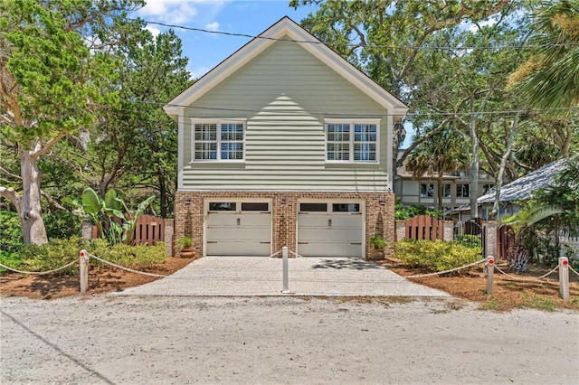 622 Beachview Dr, Saint Simons Island, GA 31522 - view of front of house featuring brick siding, concrete driveway, and an attached garage