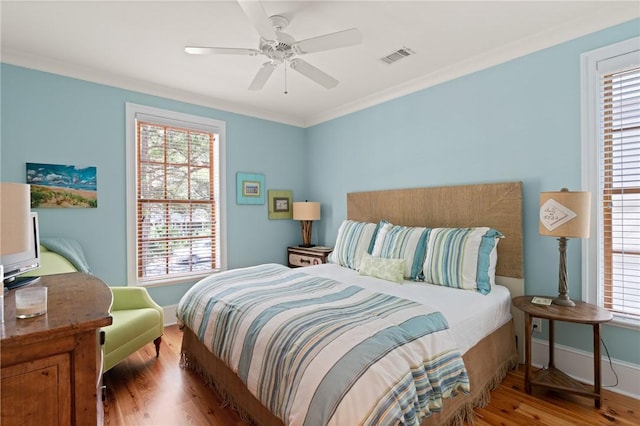 622 Beachview Dr, Saint Simons Island, GA 31522 - bedroom featuring wood finished floors, ornamental molding, multiple windows, and a ceiling fan