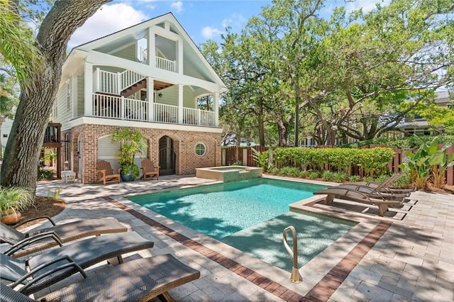 622 Beachview Dr, Saint Simons Island, GA 31522 - rear view of property featuring a patio area, a balcony, brick siding, and a pool with connected hot tub