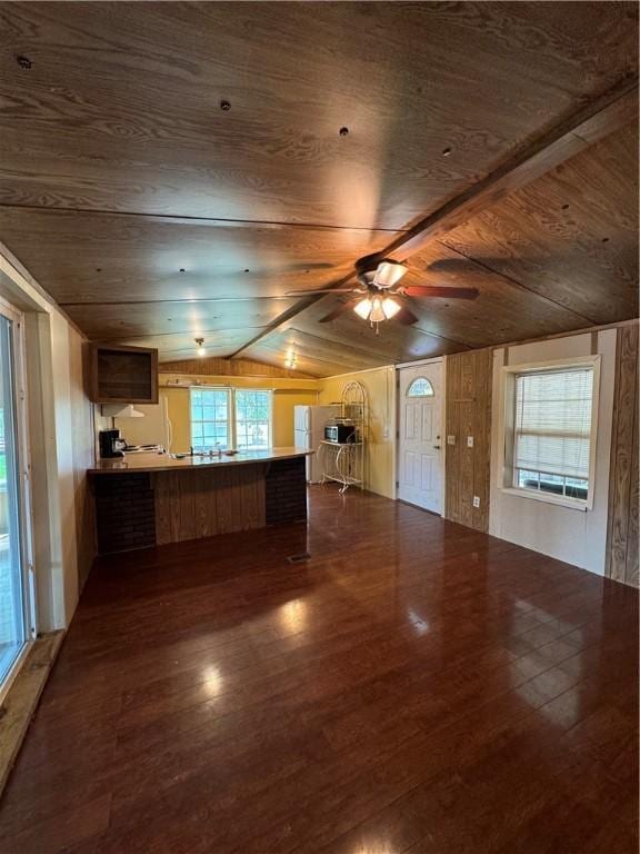 145 Getaway Ln, Surrency, GA 31563 - unfurnished living room with lofted ceiling, wood ceiling, dark wood-style floors, wooden walls, and a ceiling fan