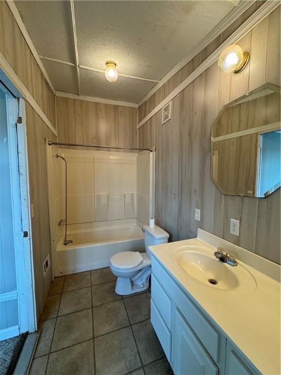 full bathroom with shower / bathing tub combination, vanity, wood walls, tile patterned floors, and toilet